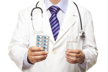 Doctor holding glass of water and pills on white background 