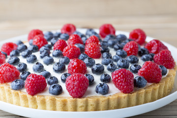 Cake with blueberries and raspberries. Confectionery product.
