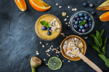 Fruit smoothie with ingredients on the stone table