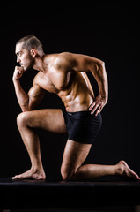 Obraz premium Muscular man posing in dark studio