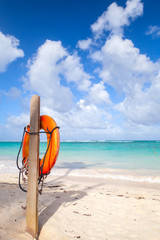 Obraz premium Red life buoy hanging on wooden pole