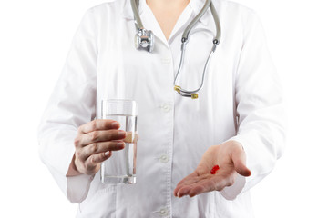 Female doctor's hand holding glass of water, giving pills isolat