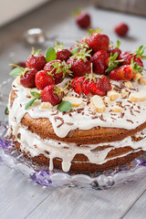 Cake with white cream decorated by strawberries