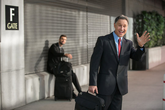 Two business men await a ride after arriving from flight
