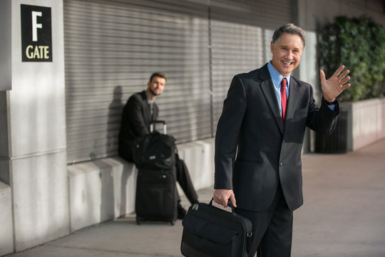 Man in suit with briefcase at the airport looking for transportation