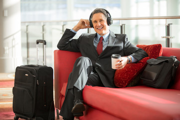 Man in suit listens to podcast while on business travel trip