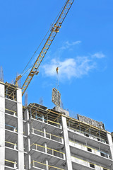Crane hoisting formwork over construction site work