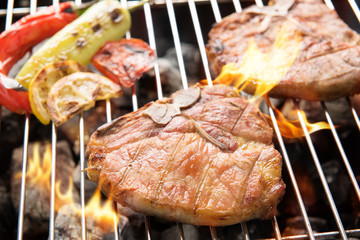 Grilled pork chop and vegetables on the flaming grill