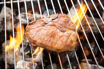 Grilled pork chop on the flaming grill