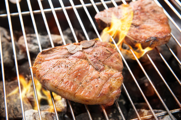 Grilled pork chop on the flaming grill
