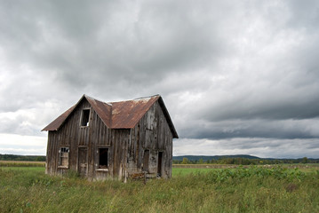 Fototapeta na wymiar Abandoned Farm House with Stormy Sky