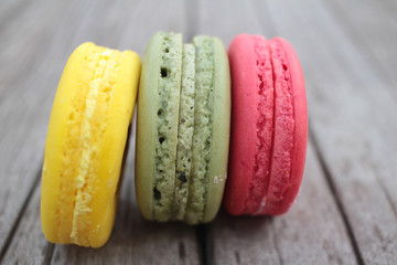 Macaroons colorful delicious on wood background.
