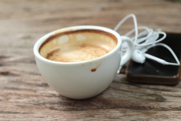 latte coffee in cup on wood background and smart phones