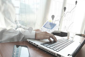 business man hand working on laptop computer on wooden desk as c