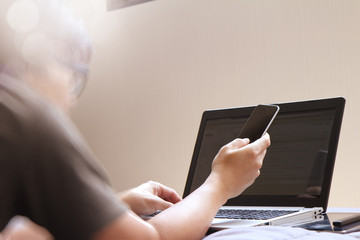 Working with smart phone and computer in bed as concept