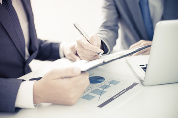 Two businessmen looking at report and having a discussion in off