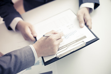 Two businessmen looking at report and having a discussion in off