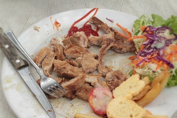 steaks and vegetable salad with french fries.