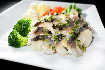 Slice steamed fish with braised leeks topping and spicy sauce in