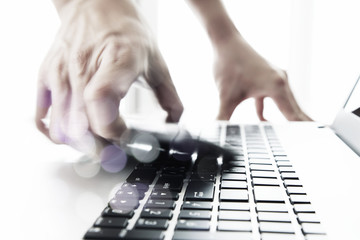 Fototapeta premium Businessman hand using laptop and mobile phone on wooden desk a