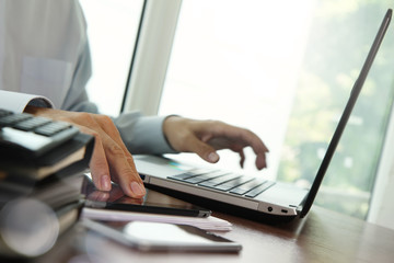 businessman hand working with digital tablet and laptop on woode