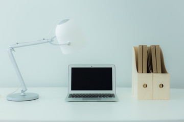 Still-life portrait of computer, pen, coffee mug on table, busin