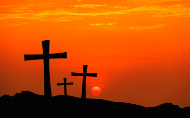 cross silhouette on mountain with sunset sky.