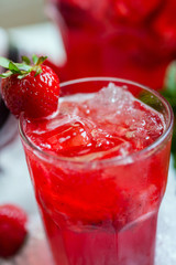 glass of cold fresh summer bright strawberry lemonade on a table