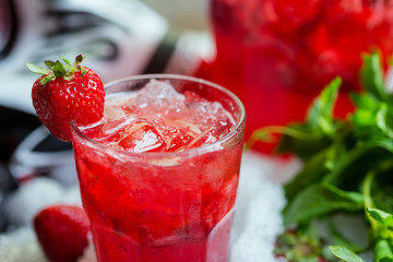 glass of cold fresh summer bright strawberry lemonade on a table