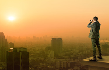 business man and binocular spying acting standing on top of offi