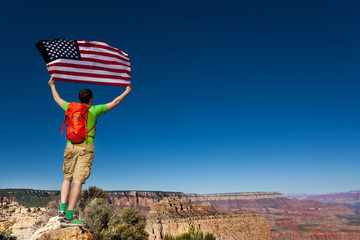 Man's back with rucksack, USA flag, Grand Canyon