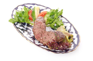 Meat on a grill with vegetables