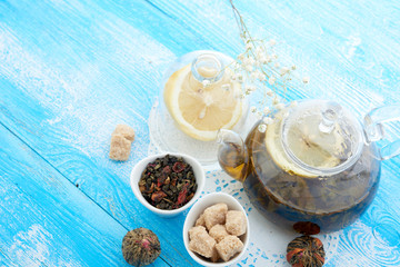 Obraz na płótnie Canvas Ripe lemon, cinnamon and fruit drink in glass teapot on wooden