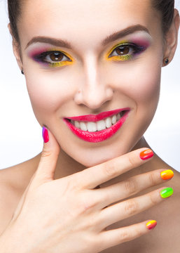 Beautiful girl with bright colored makeup and nail polish
