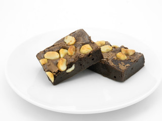 Chocolate brownie on a white plate in white background.