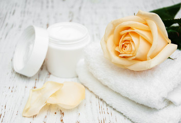 Fototapeta na wymiar Rose with moisturiser cream and towels