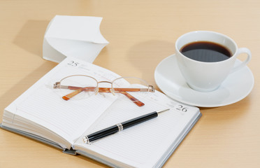 Image of planner , coffee cup pen and glasses