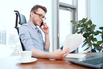 Businessman looking through papers in office 