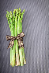 Asparagus bind with brown ribbon on blue grey background