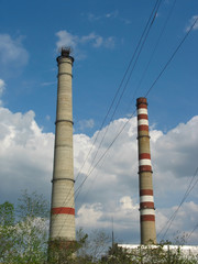 Two power plant chimneys against blue sky