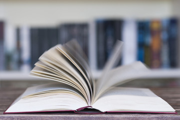 Aufgeschlagenes Buch vor Buecherregal