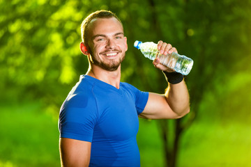 Athletic mature man drinking water from a bottle