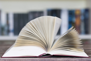 Aufgeschlagenes Buch vor Buecherregal