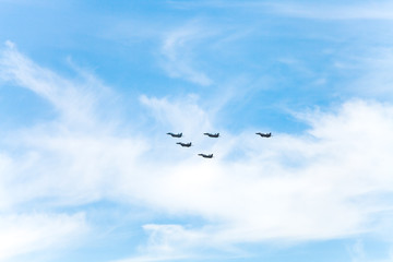 flight of military fighter planes in white clouds
