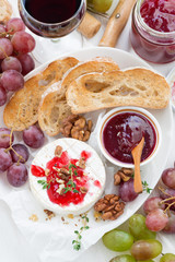 appetizers for wine - camembert with berry jam, toast and fruit