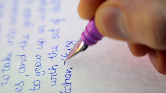 Feather fountain pen writes a letter on paper