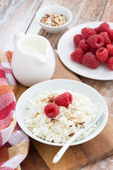 cottage cheese with fresh raspberry and milk, vertical