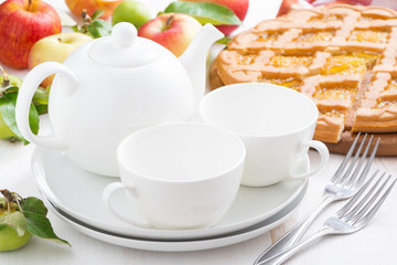 White crockery for the tea party and apple pie on table