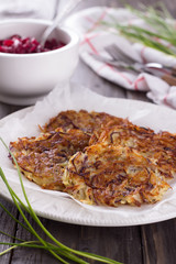 Potato fritters, beet salad, green onions on a wooden surface
