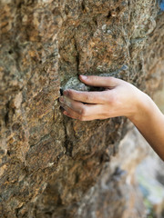 The hand holds on the rock.